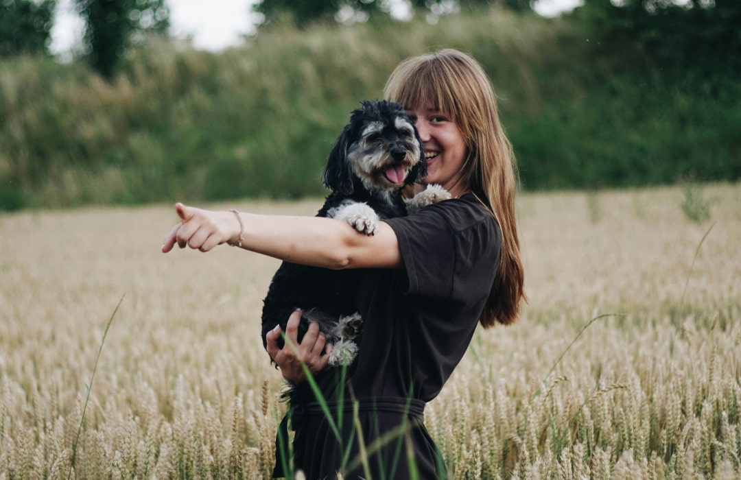 Happy girl with her pet in the field